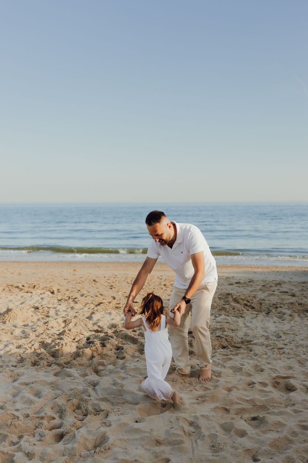 Candid family moment with waves in the background, Bournemouth beach photoshoot