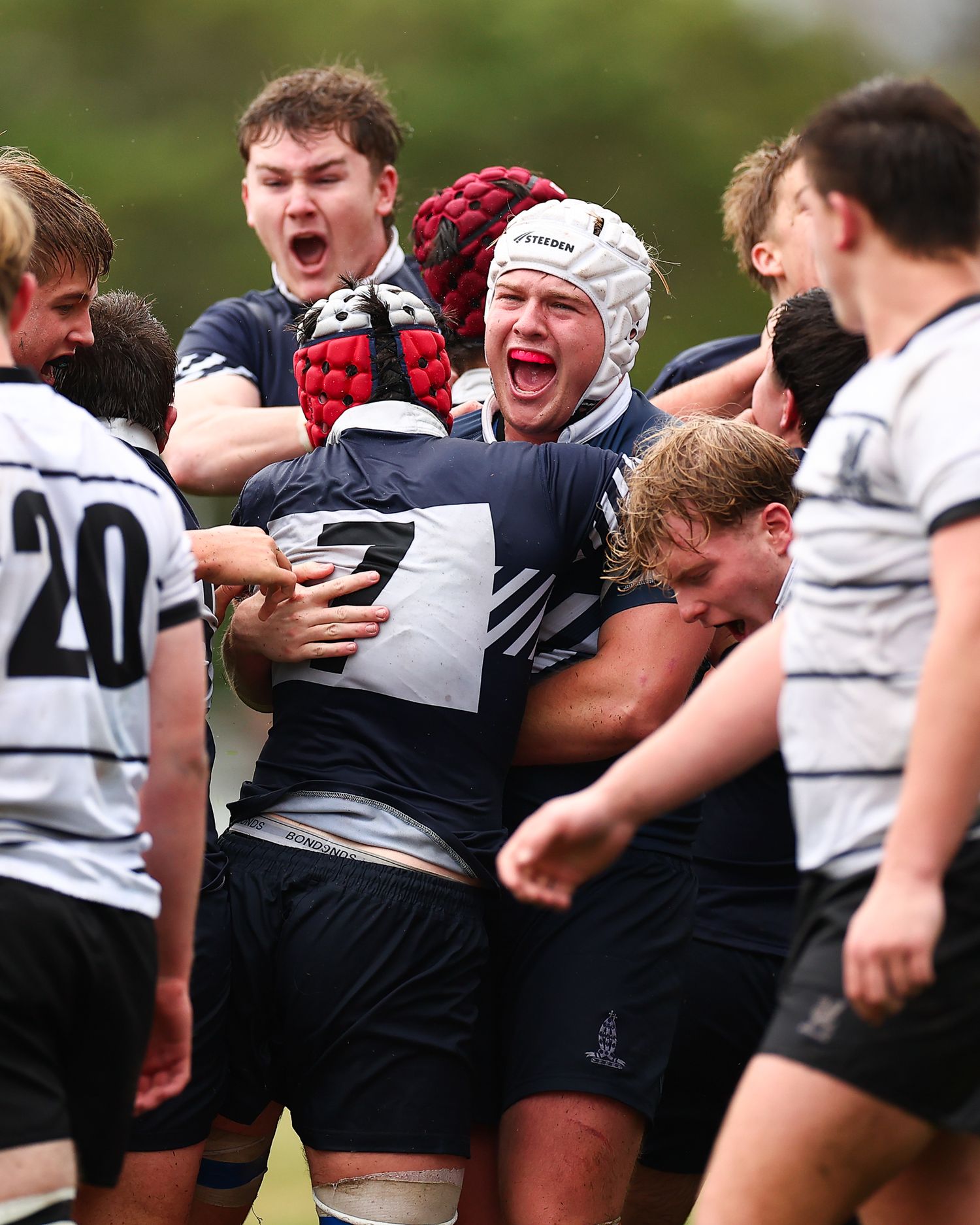 Rugby players form a scrum during intense match action.