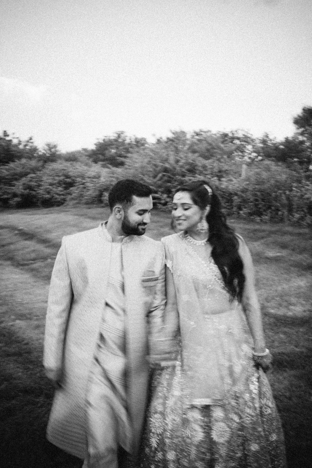 Black and white romantic couple photoshoot in a natural outdoor setting showing intimate candid moments.