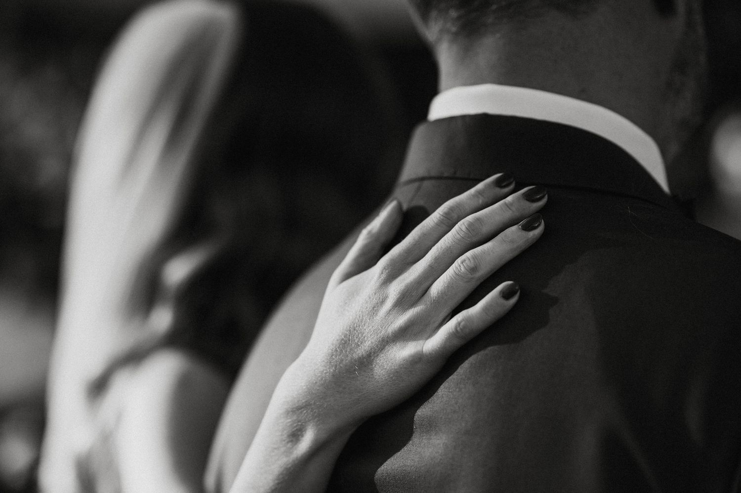 Black and white photo showing hands covering faces in sequence, creating a dramatic visual pattern.