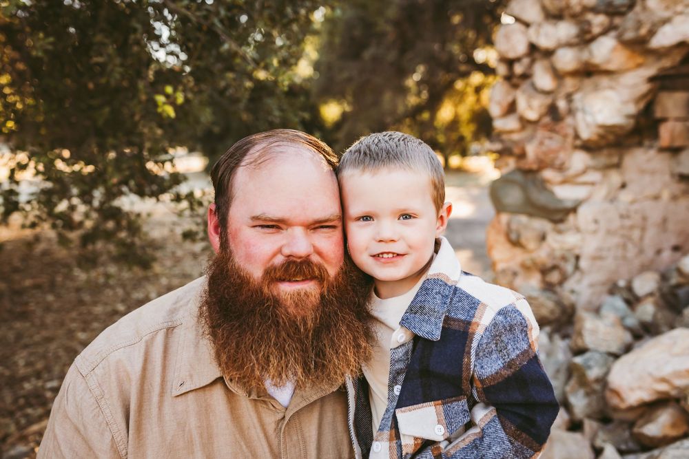 A collection of warm-toned outdoor family portrait photographs taken against a stone wall backdrop during golden hour.