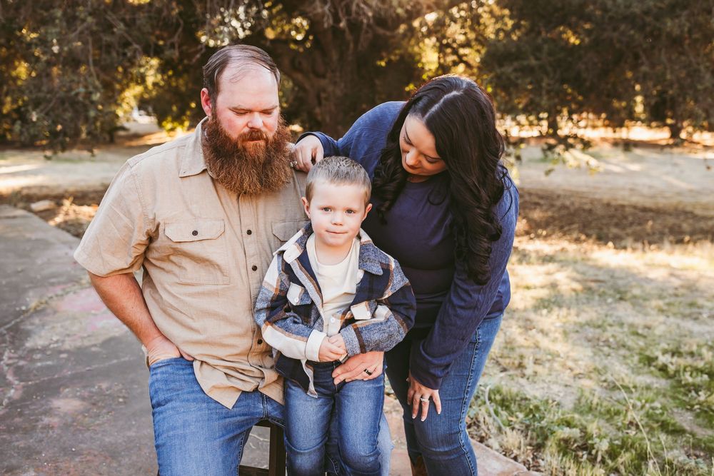 A family shares playful moments together during an outdoor sunset photoshoot.