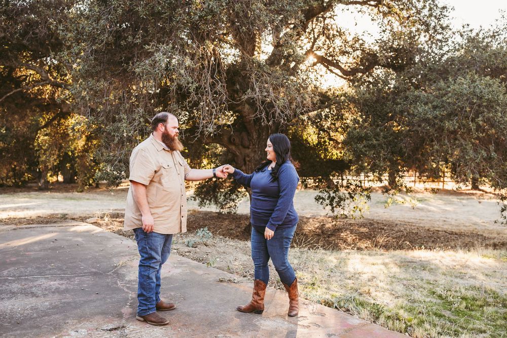 A couple walks together through a scenic outdoor setting during golden hour at sunset.