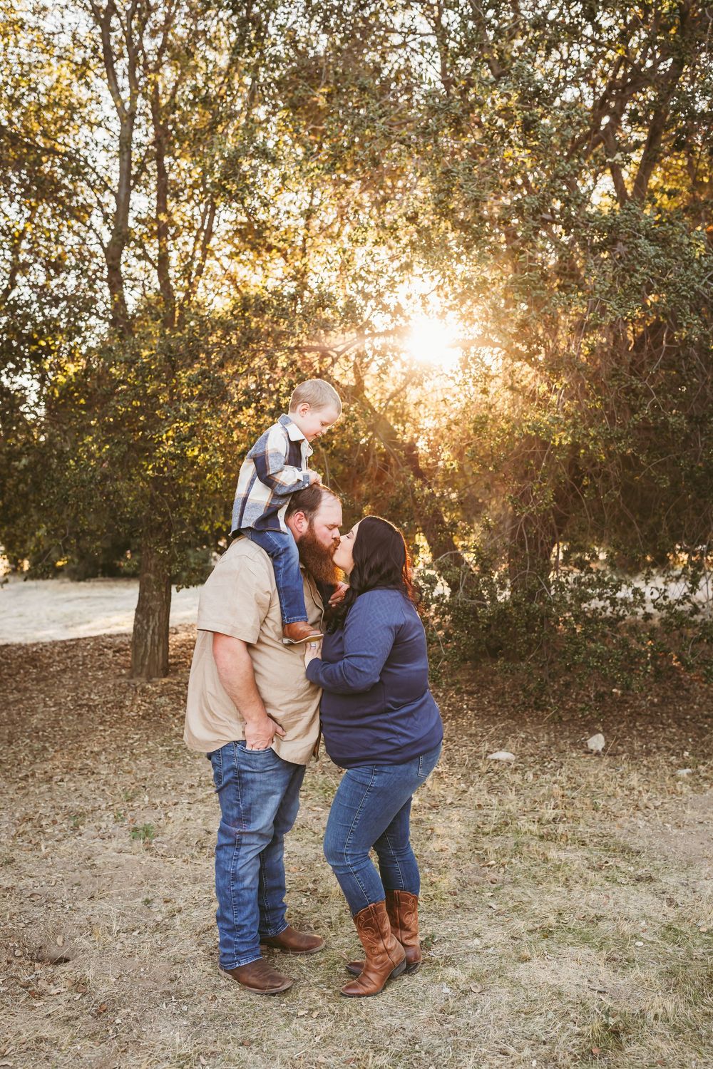 Family enjoying a golden sunset moment together in a natural outdoor setting.