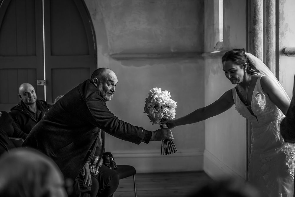 Dramatic black and white sequence showing silhouetted figures in an intimate church setting.