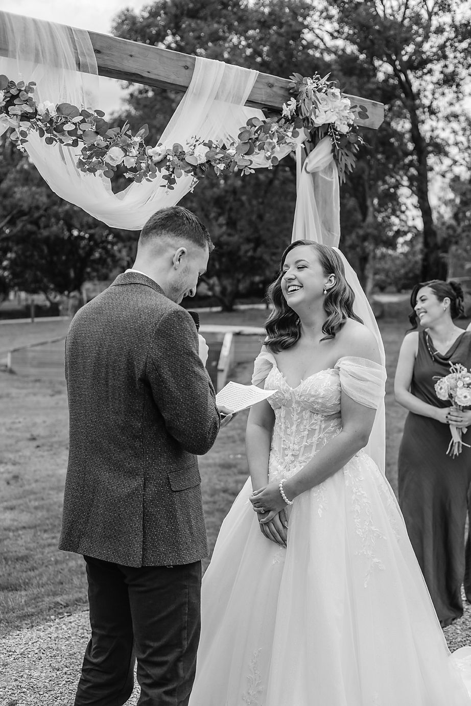 A sequence of candid black and white wedding moments showing joyful interactions between a couple outdoors.
