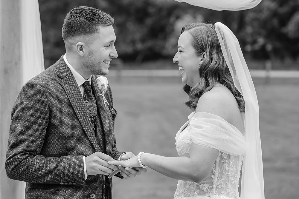 A happy couple shares joyful moments together during their outdoor wedding celebration in a garden setting.