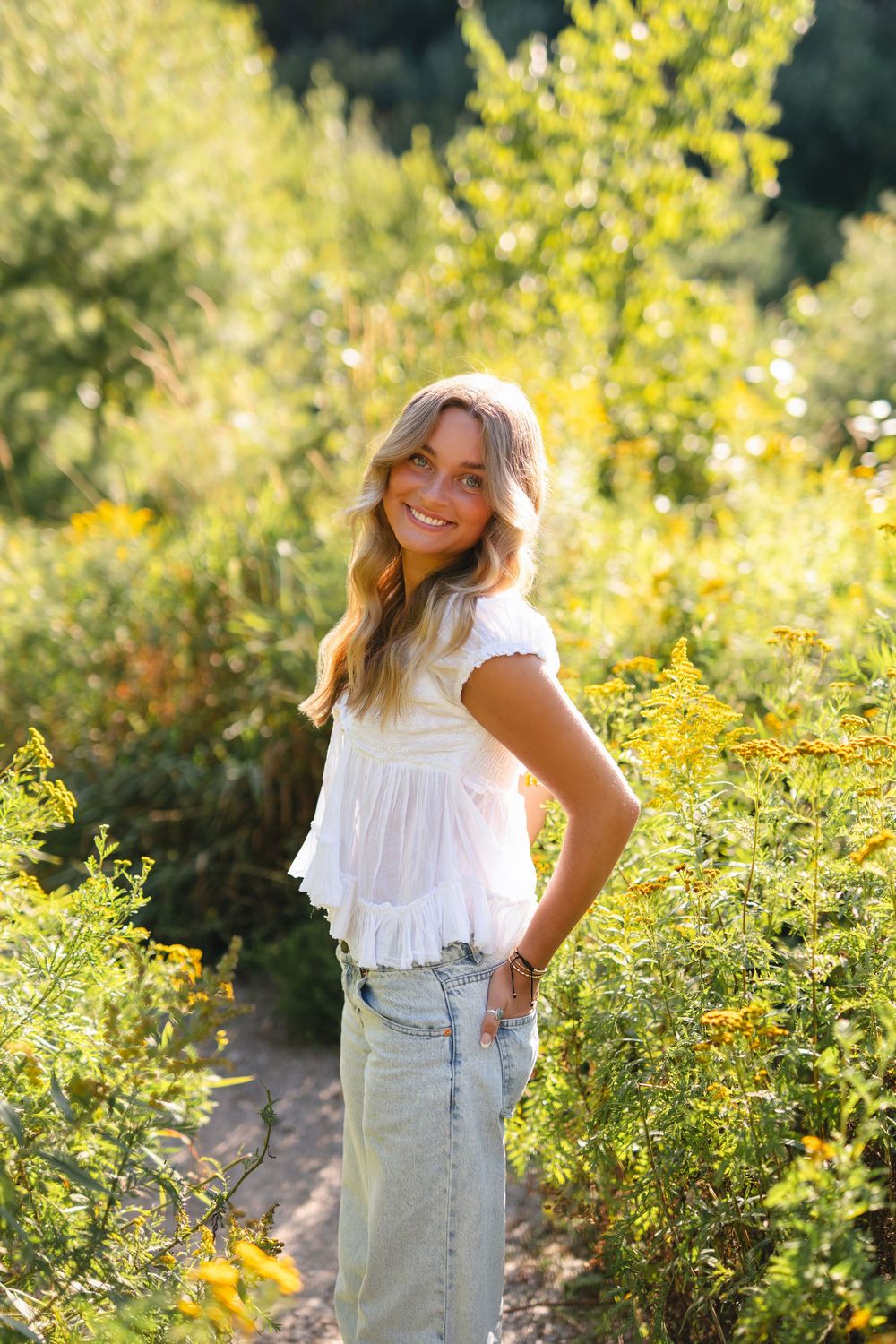 A series of outdoor portraits featuring a white ruffle top and denim overalls against a sunny yellow flower backdrop.