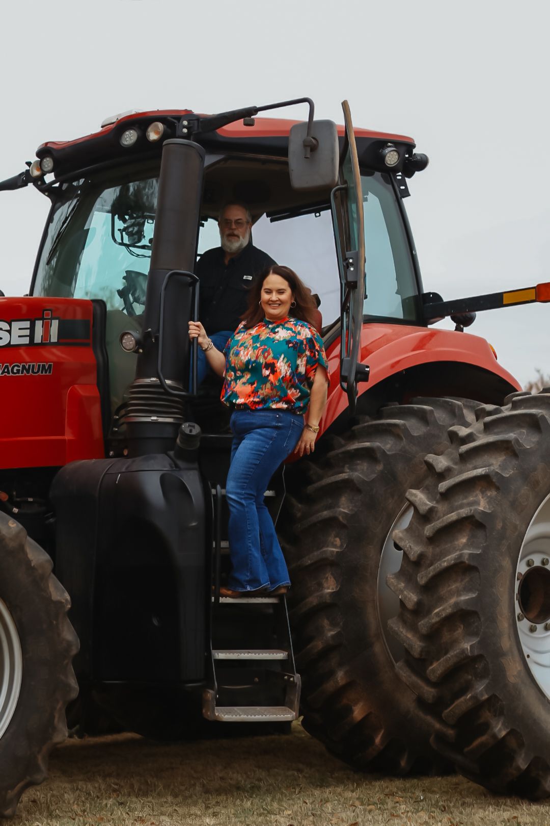 A red Case IH tractor serves as backdrop for rural photography session.