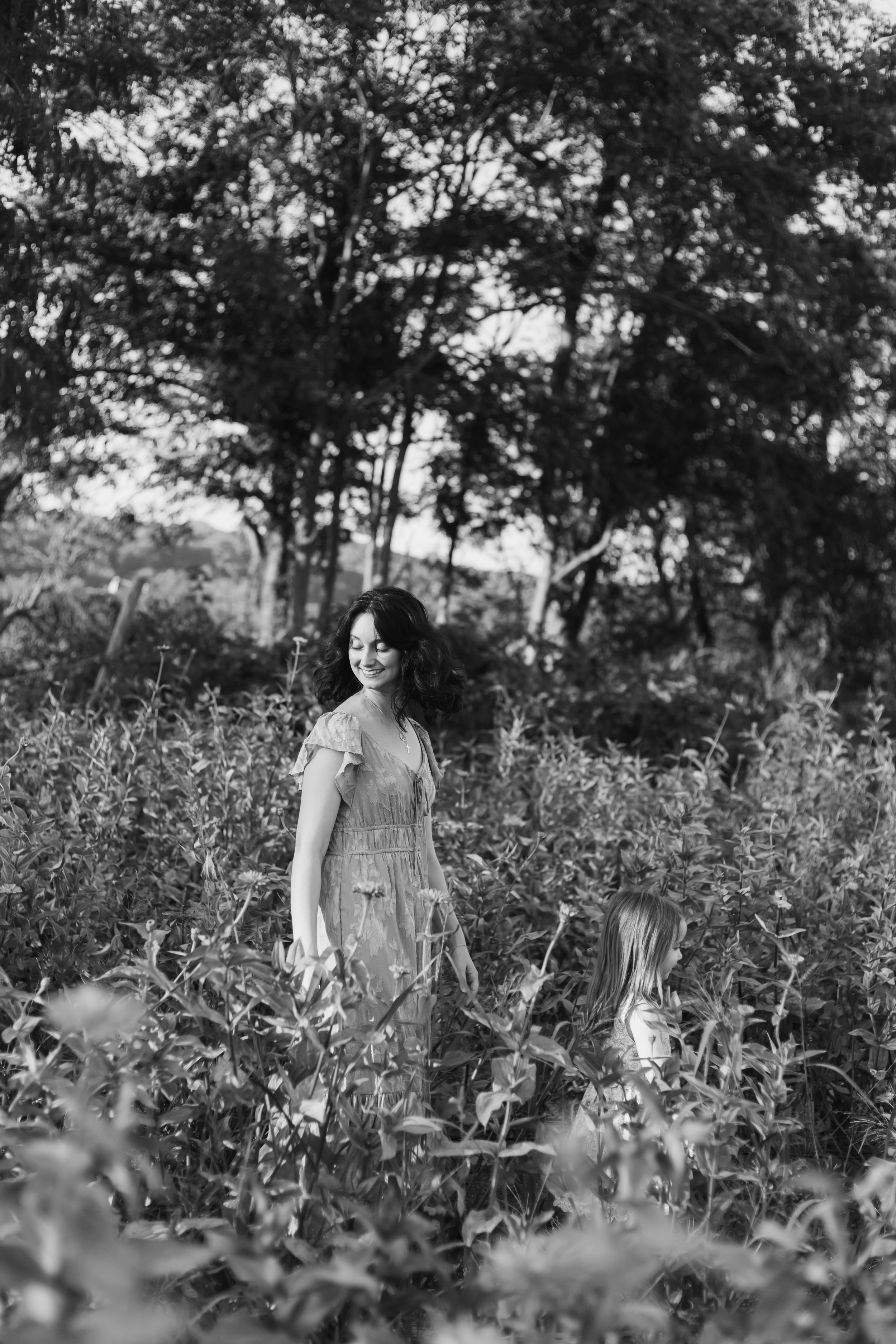 Black and white photo series of someone walking through a wildflower meadow on a sunny summer day.