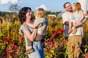 A family enjoying time together in a vibrant flower field during golden hour.