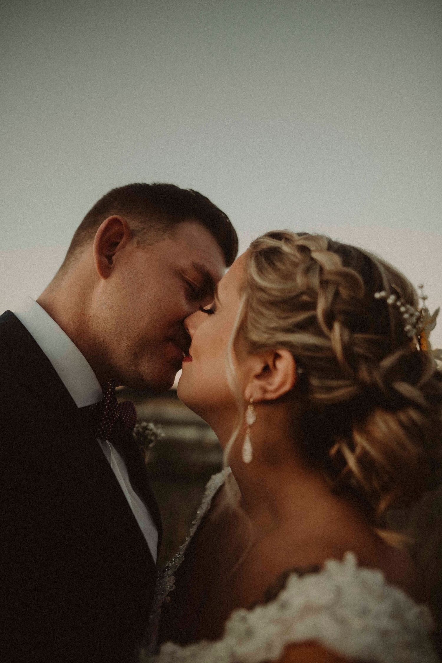 A romantic wedding portrait showing a couple in an intimate moment with moody lighting and elegant styling.