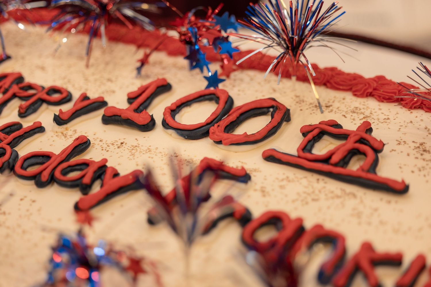Close-up of decorative red and blue text engraving on a textured surface.