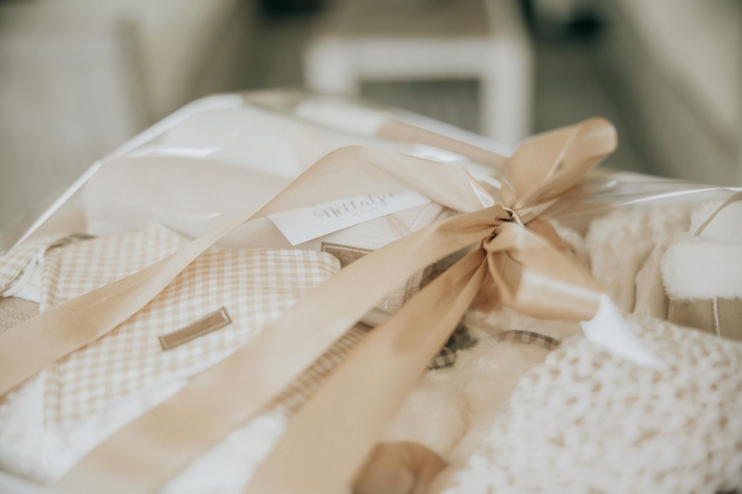 A delicate cream-colored pillow with a satin bow tied around it in soft focus.