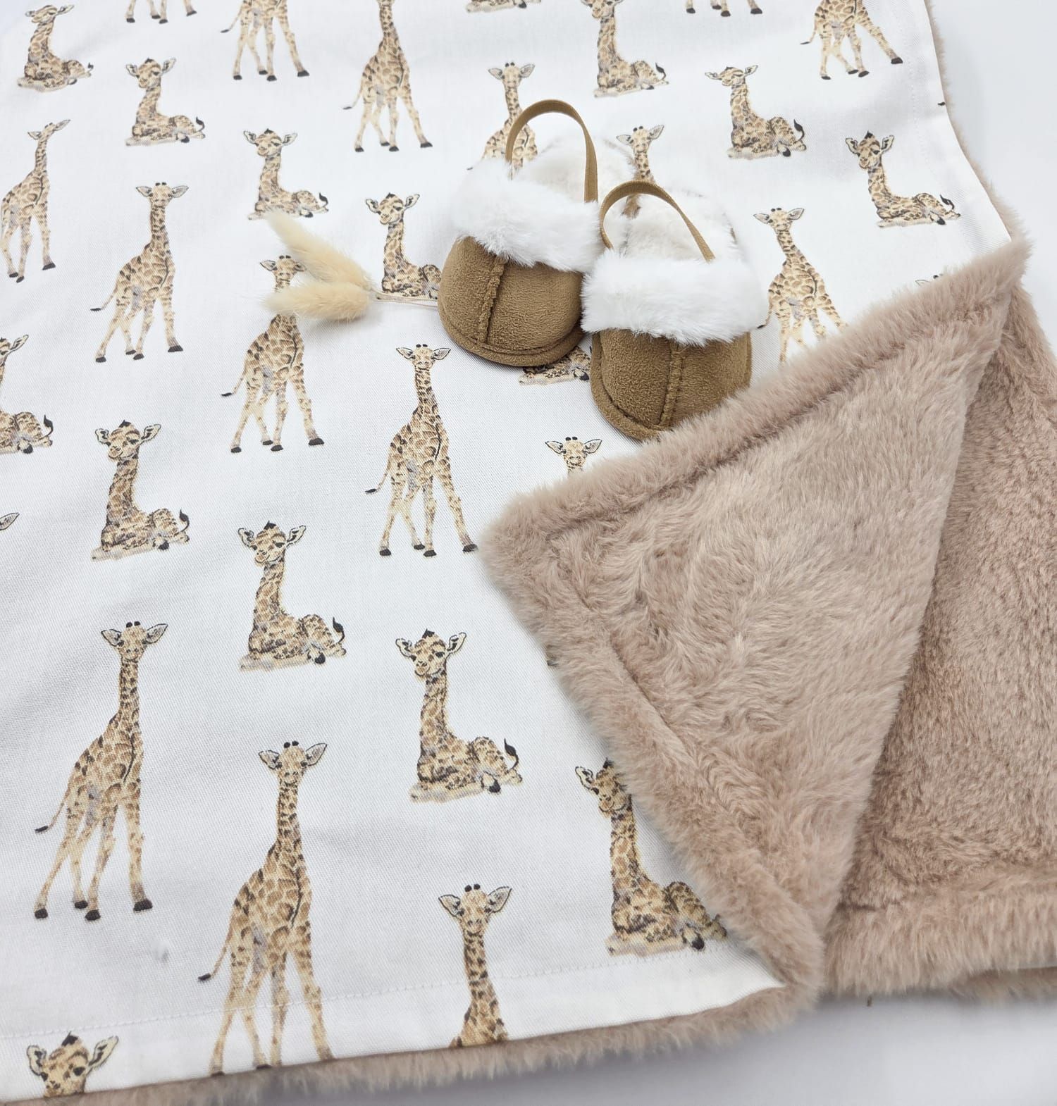 Baby blanket with giraffe pattern print and soft beige plush lining, paired with cozy fur-trimmed booties.