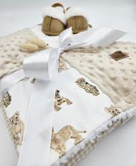 Soft beige minky baby blanket with animal print pattern and white satin bow detail.