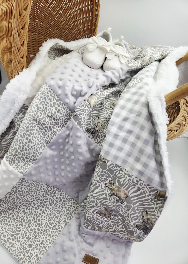 Close-up view of gray and white patchwork baby blanket with minky fabric and gingham pattern showing texture details.