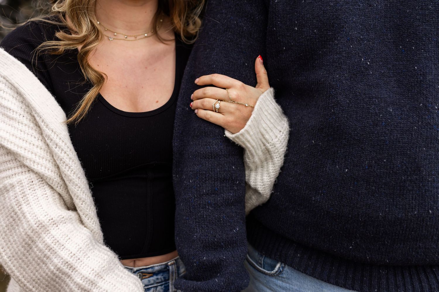 Engagement session detail of couple holding hands, ring focus with natural candid styling