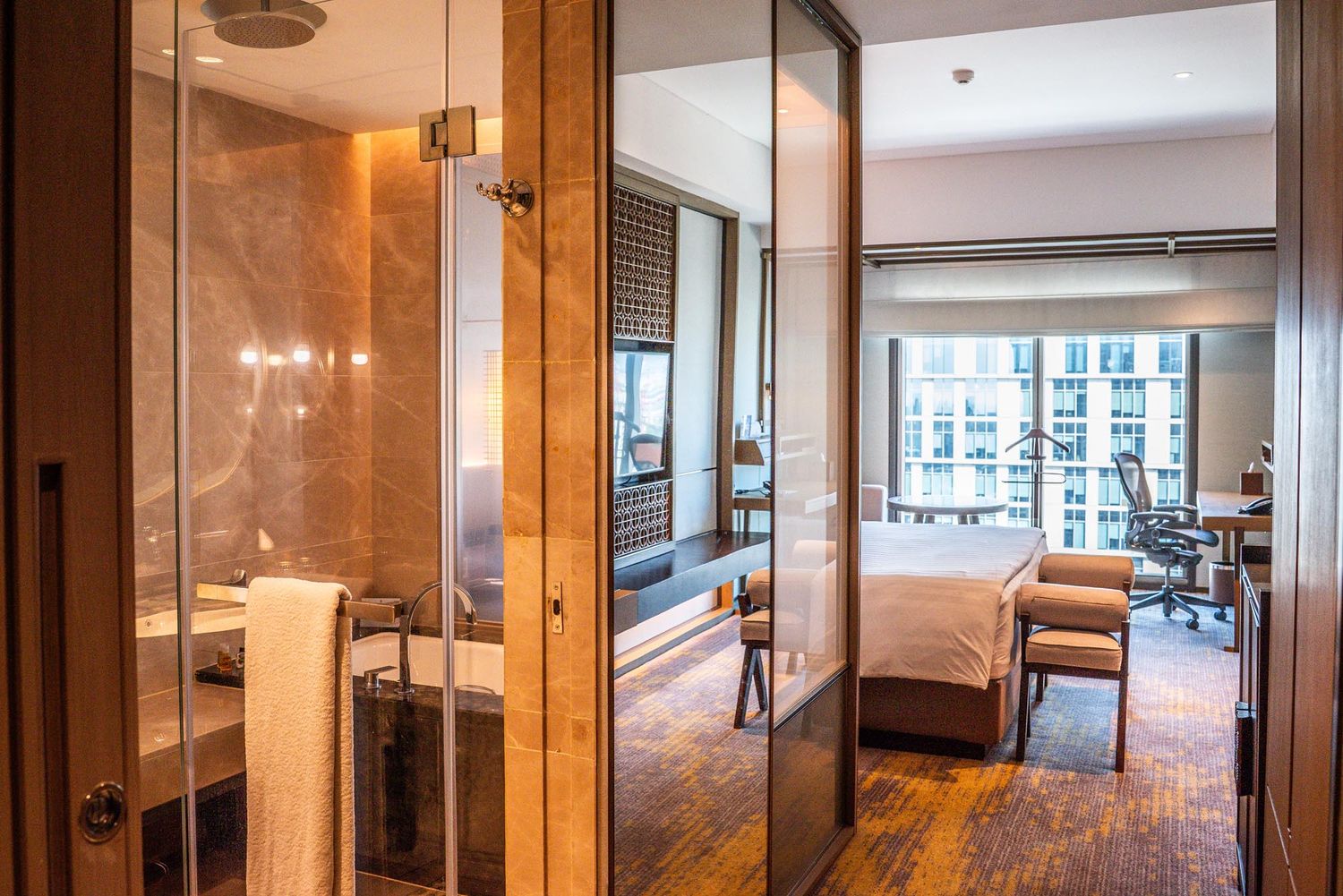 Modern open concept apartment interior with hardwood floors and floor-to-ceiling windows offering natural light.