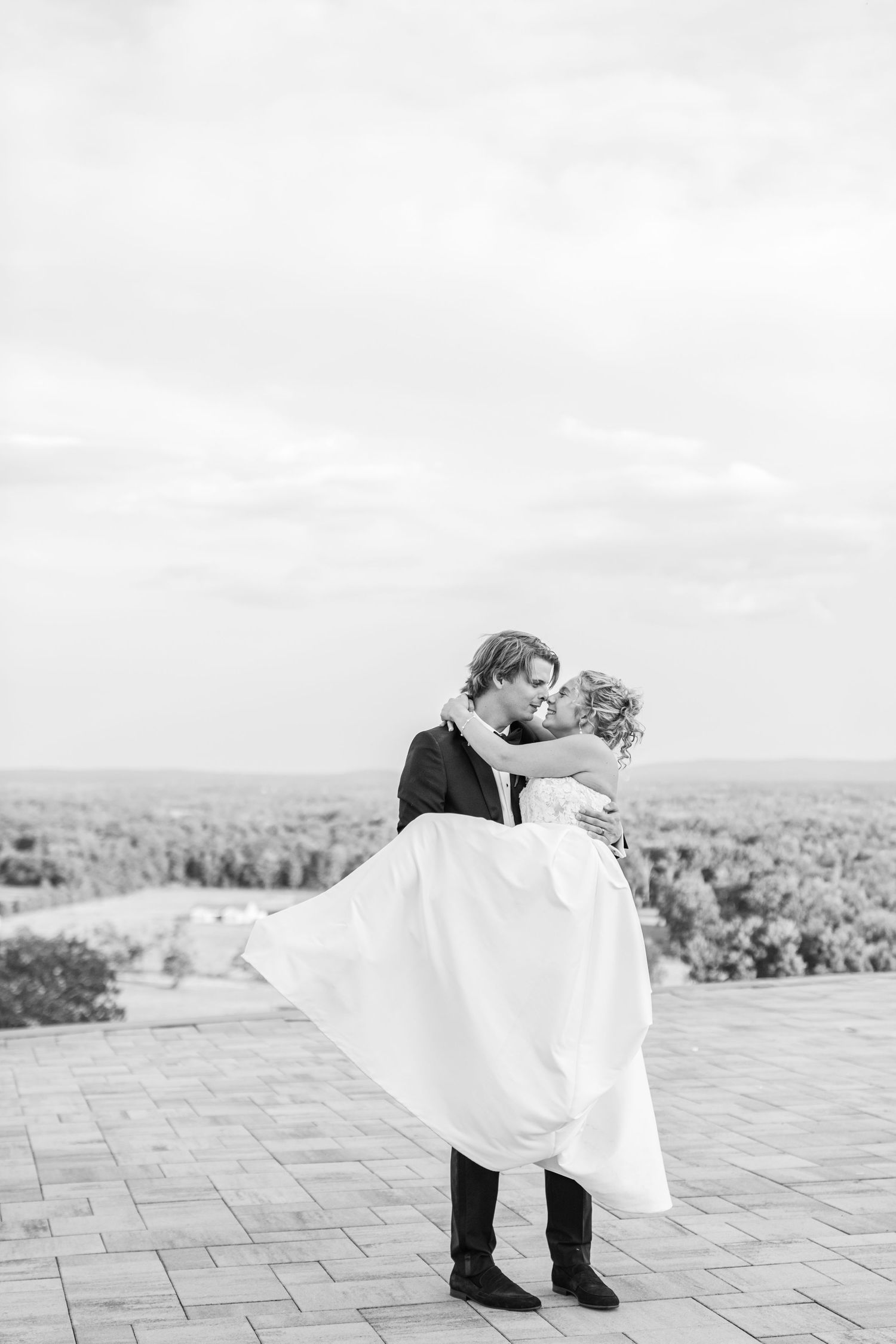 Black and white romantic wedding portrait on an outdoor terrace with flowing dress.