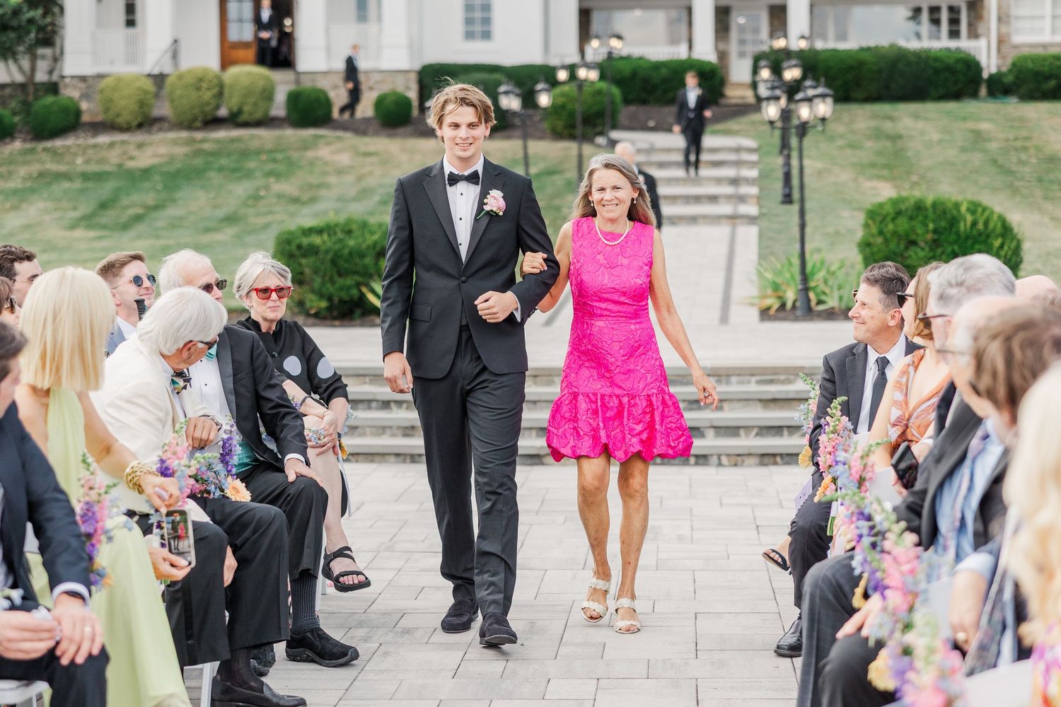 Wedding guests gathered on stone patio during outdoor celebration.