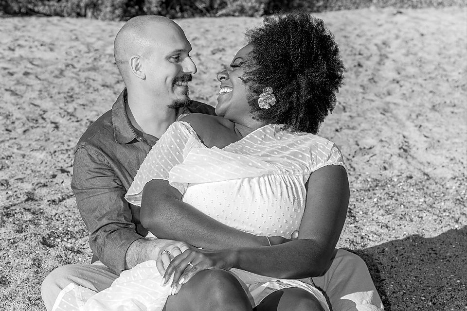 A series of romantic black and white photos showing a couple embracing outdoors on a sunny day.