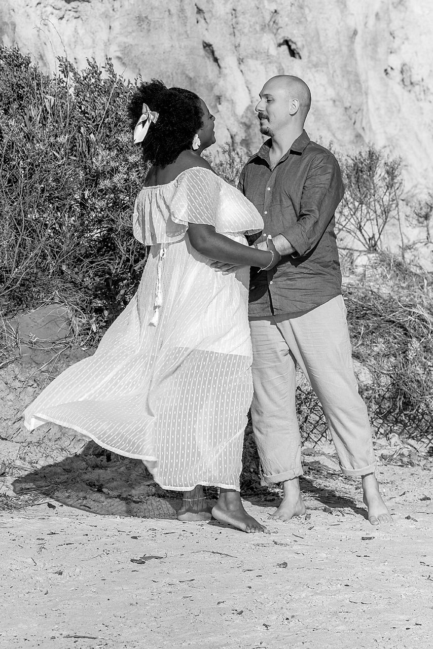 A sequence of black and white photographs showing two people dancing together against a stone wall outdoors.