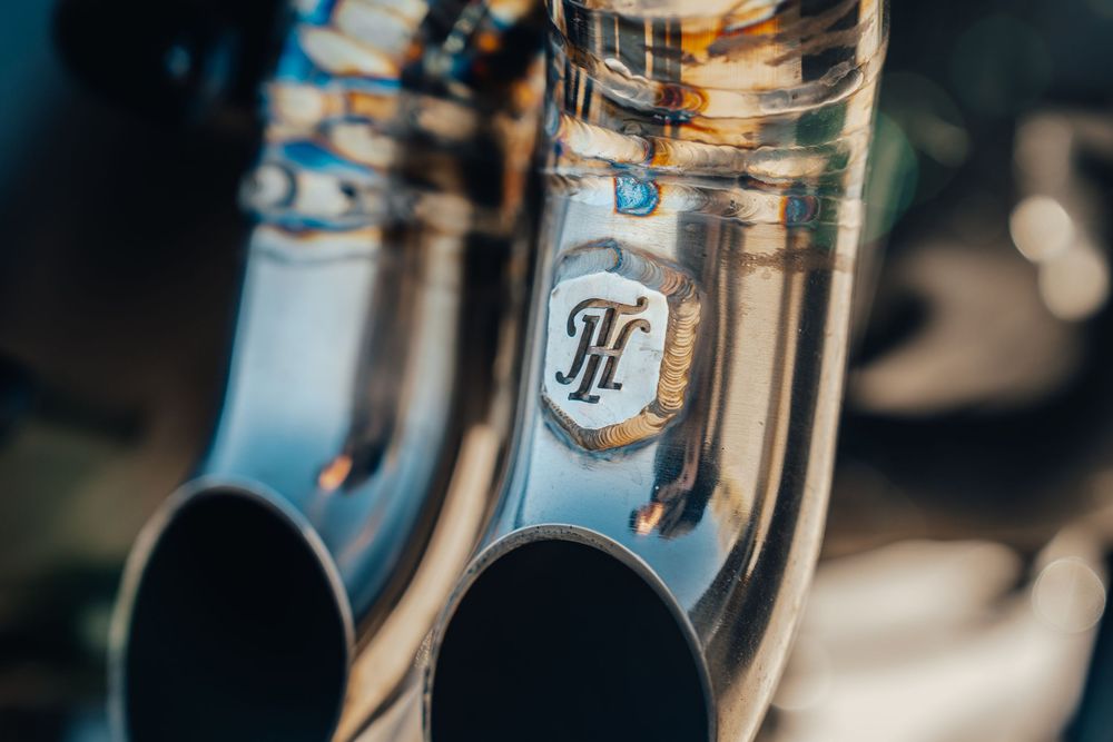 Close-up detail of shiny brass musical instrument with PH logo engraved on silver metal surface.
