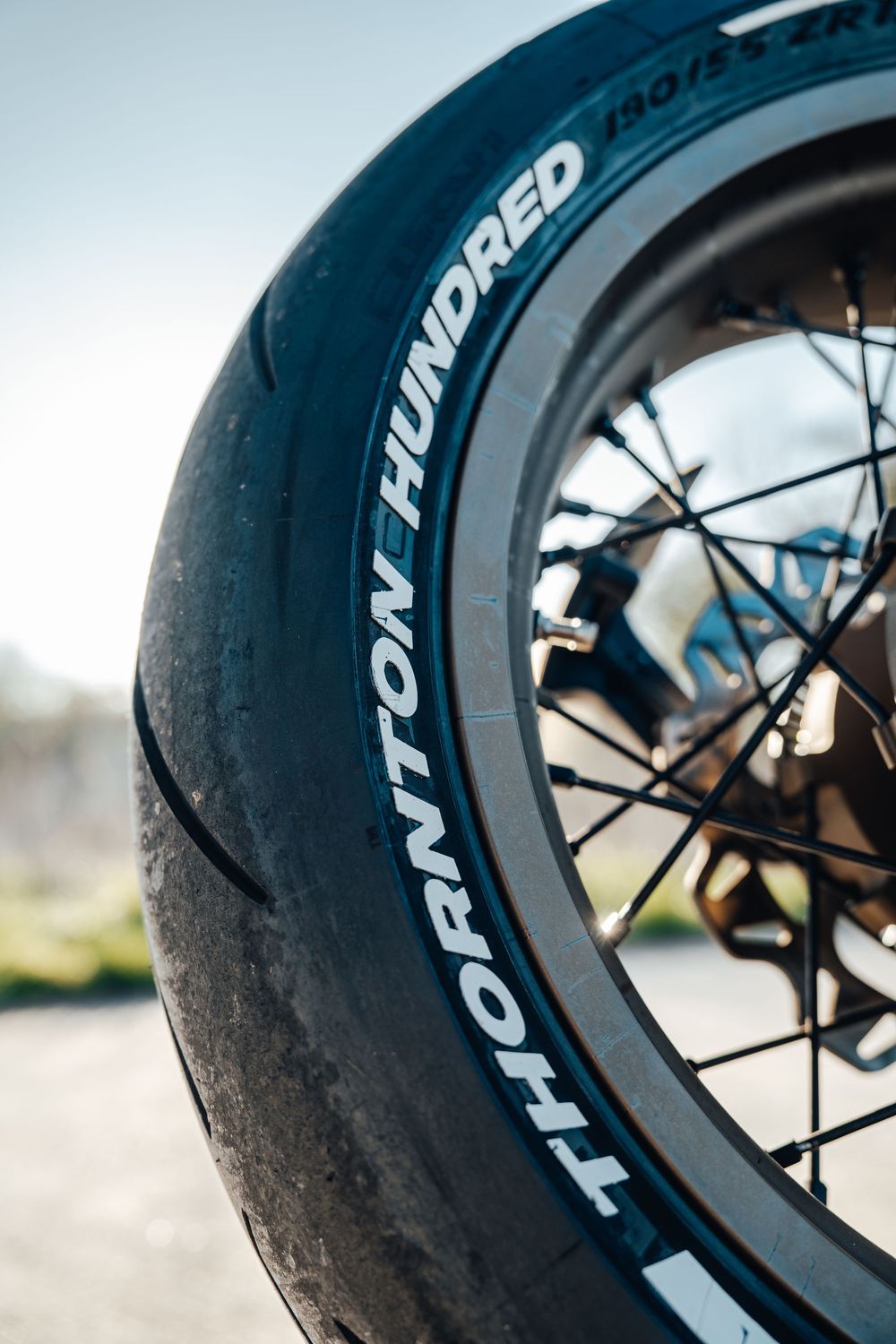Close-up view of a motorcycle tire with Tourance branding showing detailed tread pattern and sidewall markings.