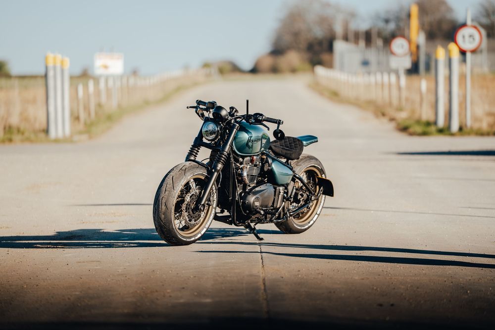 Multiple angles of a vintage-style blue motorcycle parked on a concrete surface against industrial backdrop.