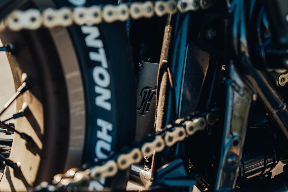 Close-up shot of bicycle chain gears and mechanical parts with a dark blue background.