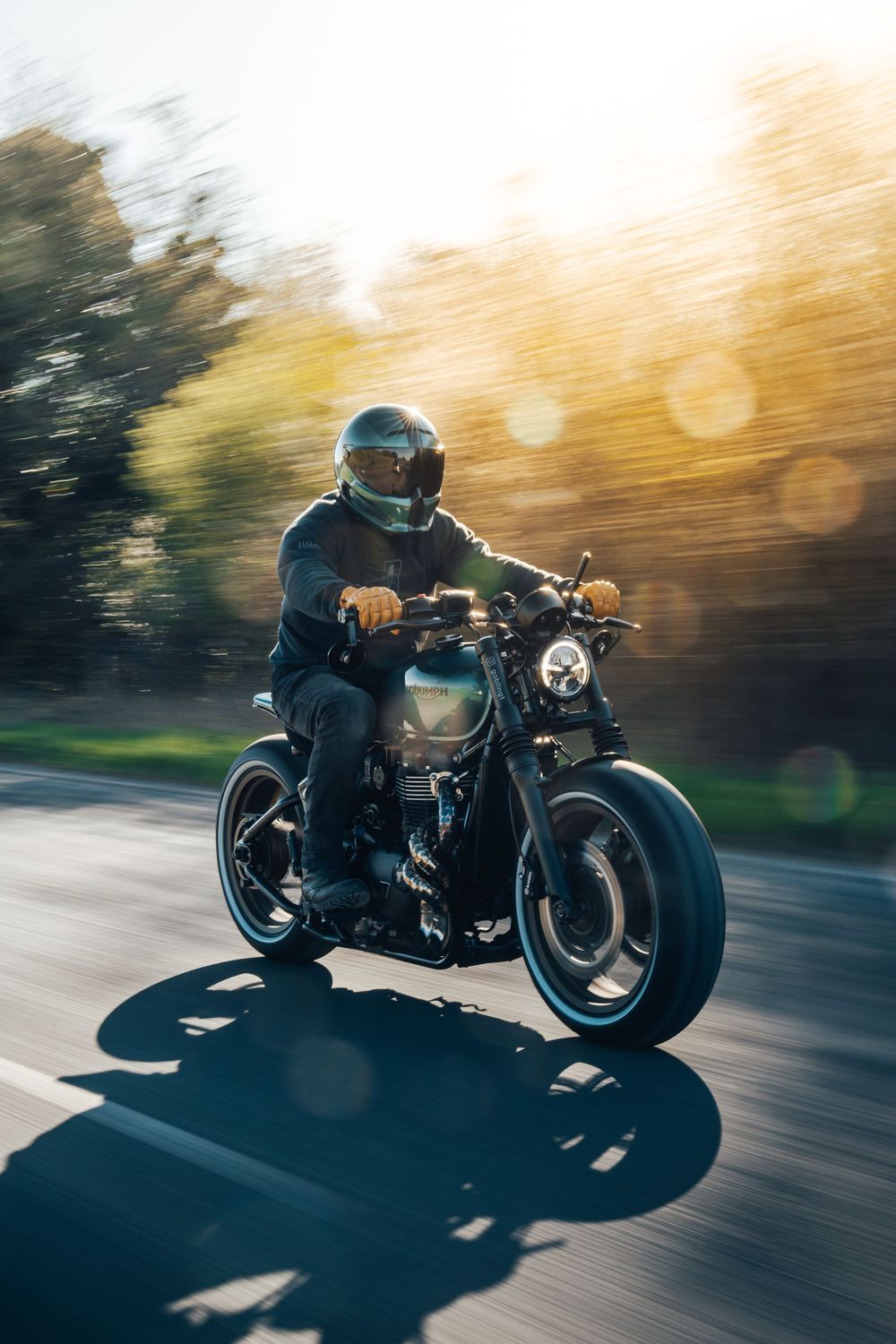 Custom motorcycle in action shots during sunset with motion blur and golden lighting effects.