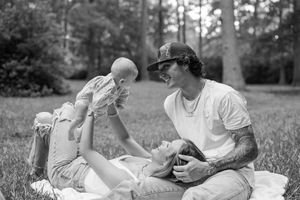 A black and white photo collage showing intimate outdoor moments between a couple sitting on grass and blankets.