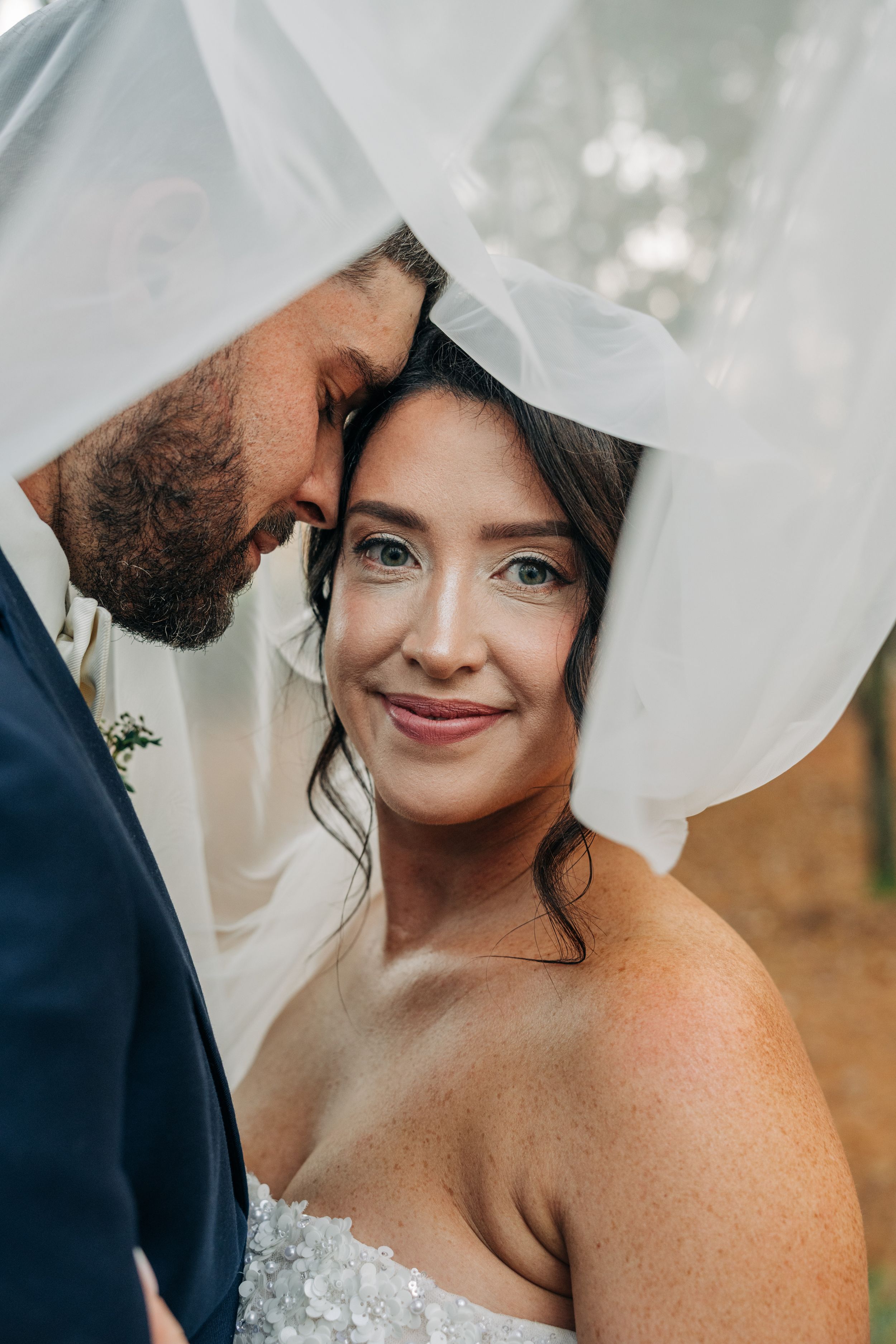 A romantic wedding photo sequence showing intimate moments between a couple through a flowing white veil.