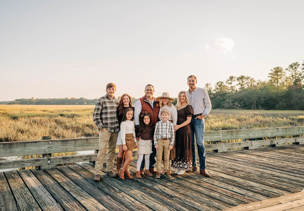 A series of candid outdoor family photos taken at sunset on a rustic wooden deck overlooking a golden field.