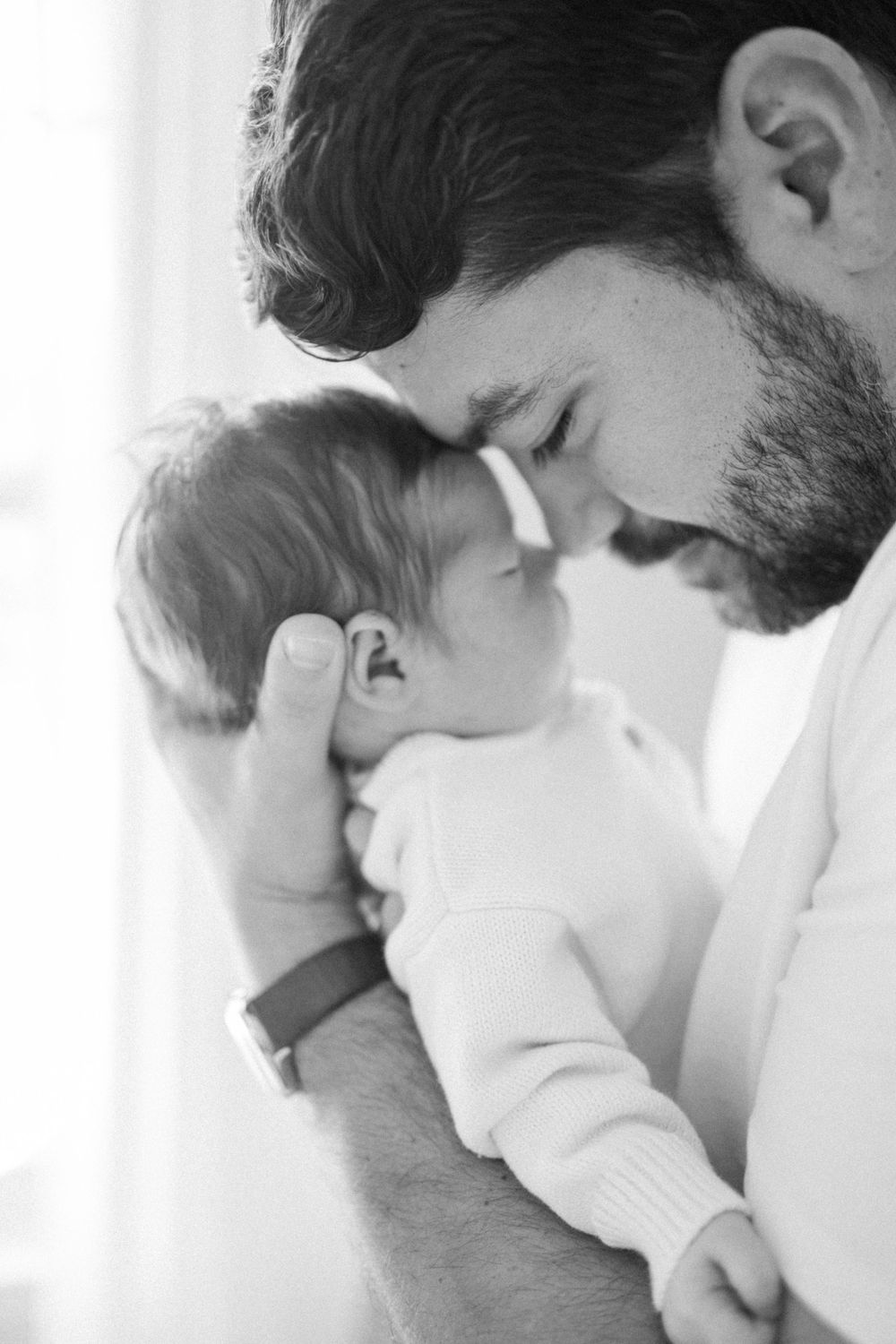 Intimate black and white portrait of tender moment with sleeping infant.