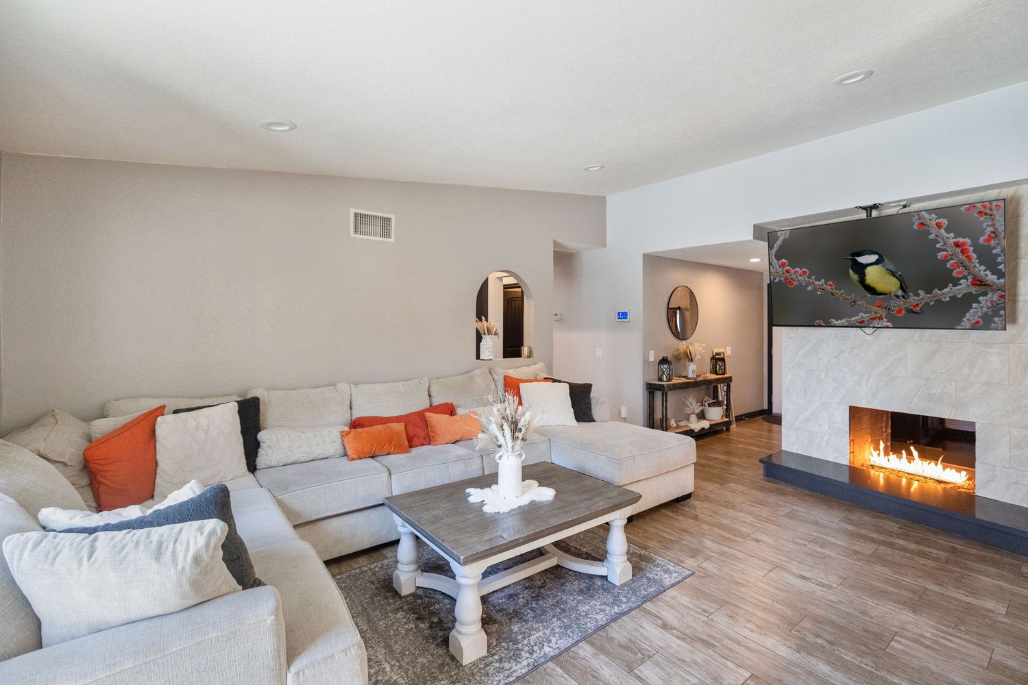 Modern minimalist living room interior with fireplace and neutral decor.