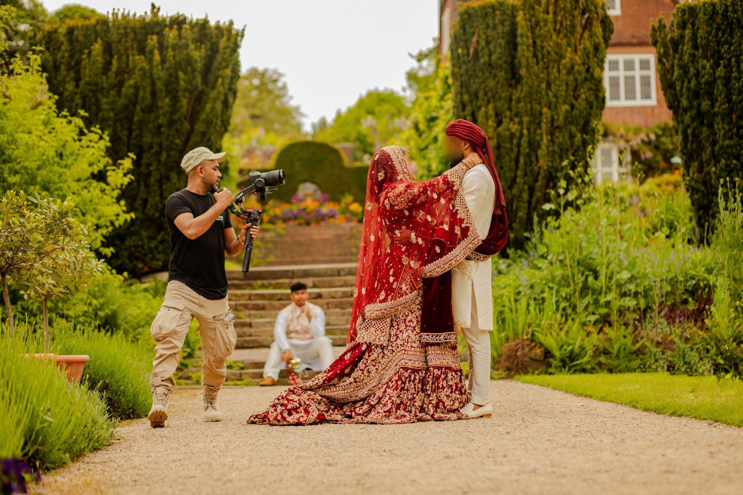 Muhammad filming a bride and groom with a gimbal during their garden wedding portraits