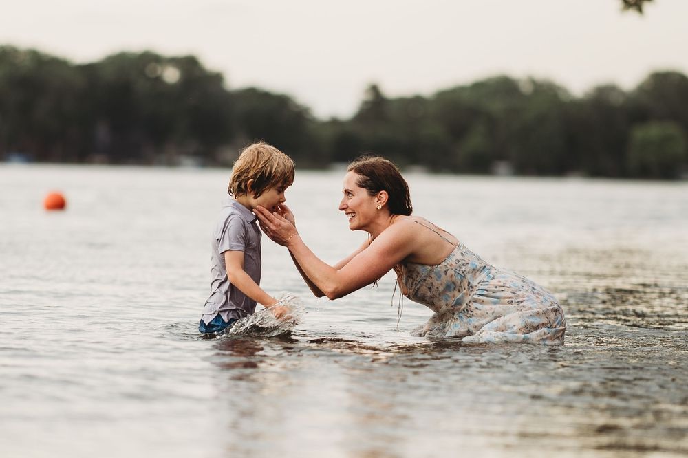 People playfully interact in the water during a warm summer day at the lake.