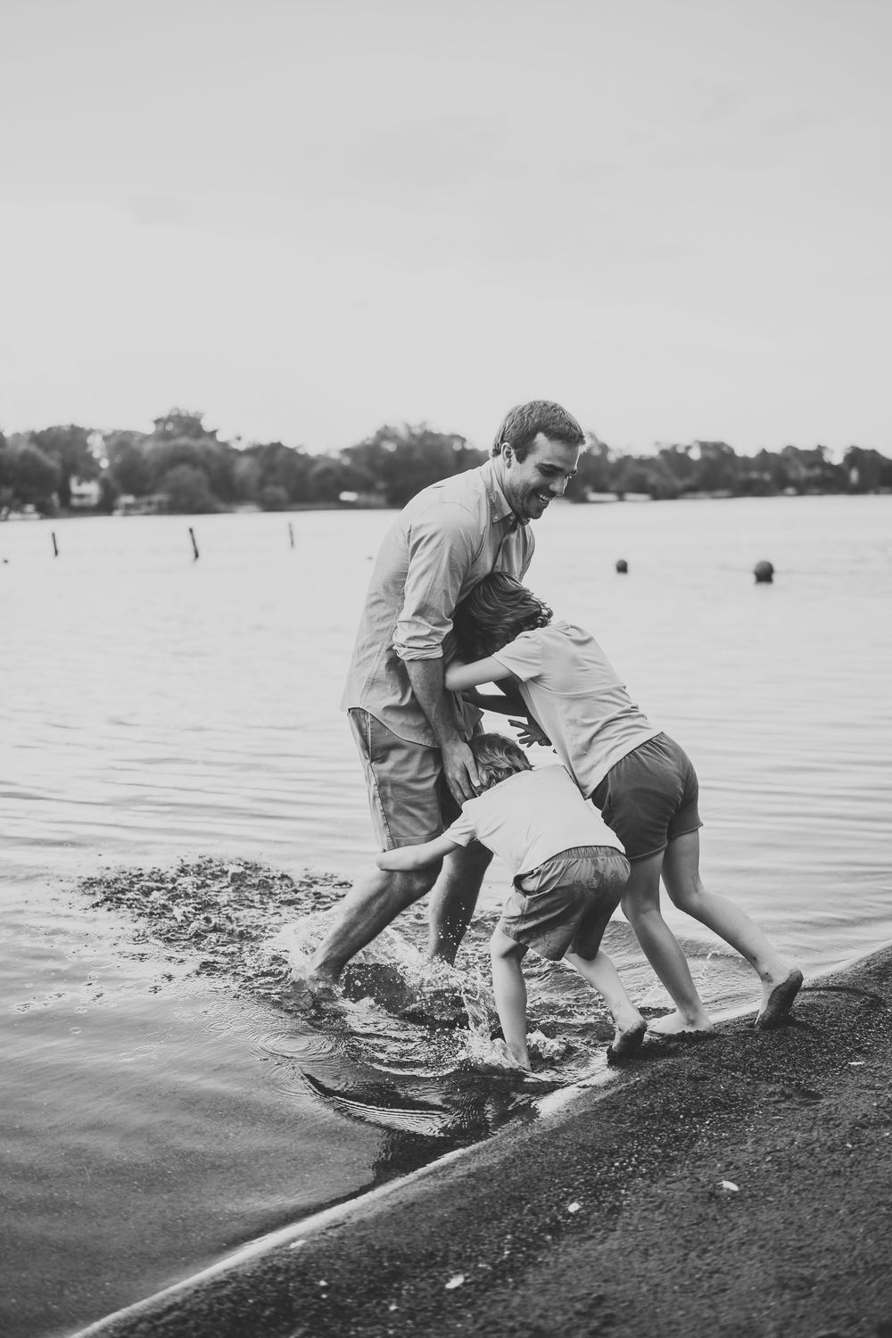 Playful splashing and fun at the water's edge in black and white.
