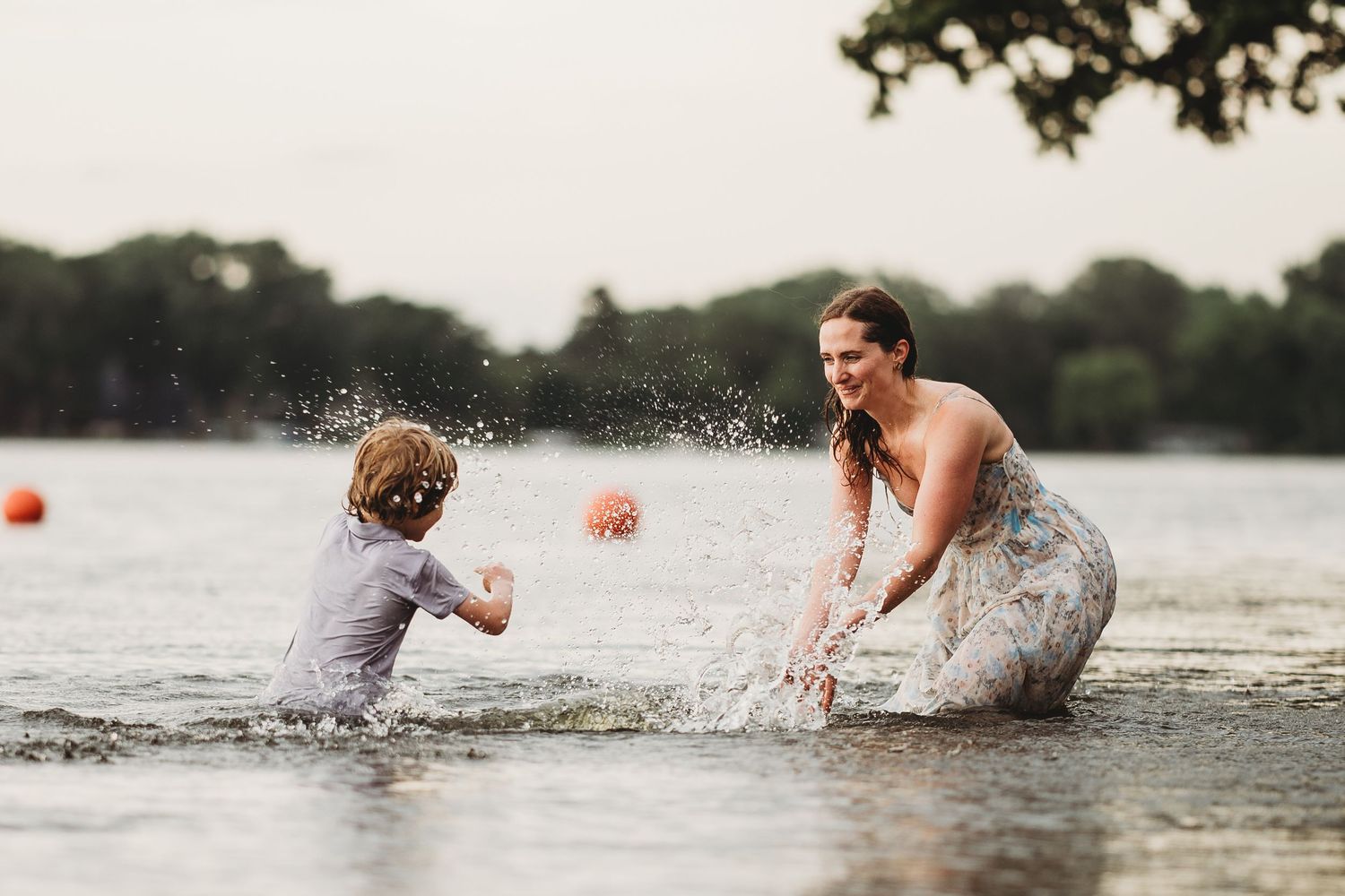 People playing and splashing in a lake during a fun summer activity.