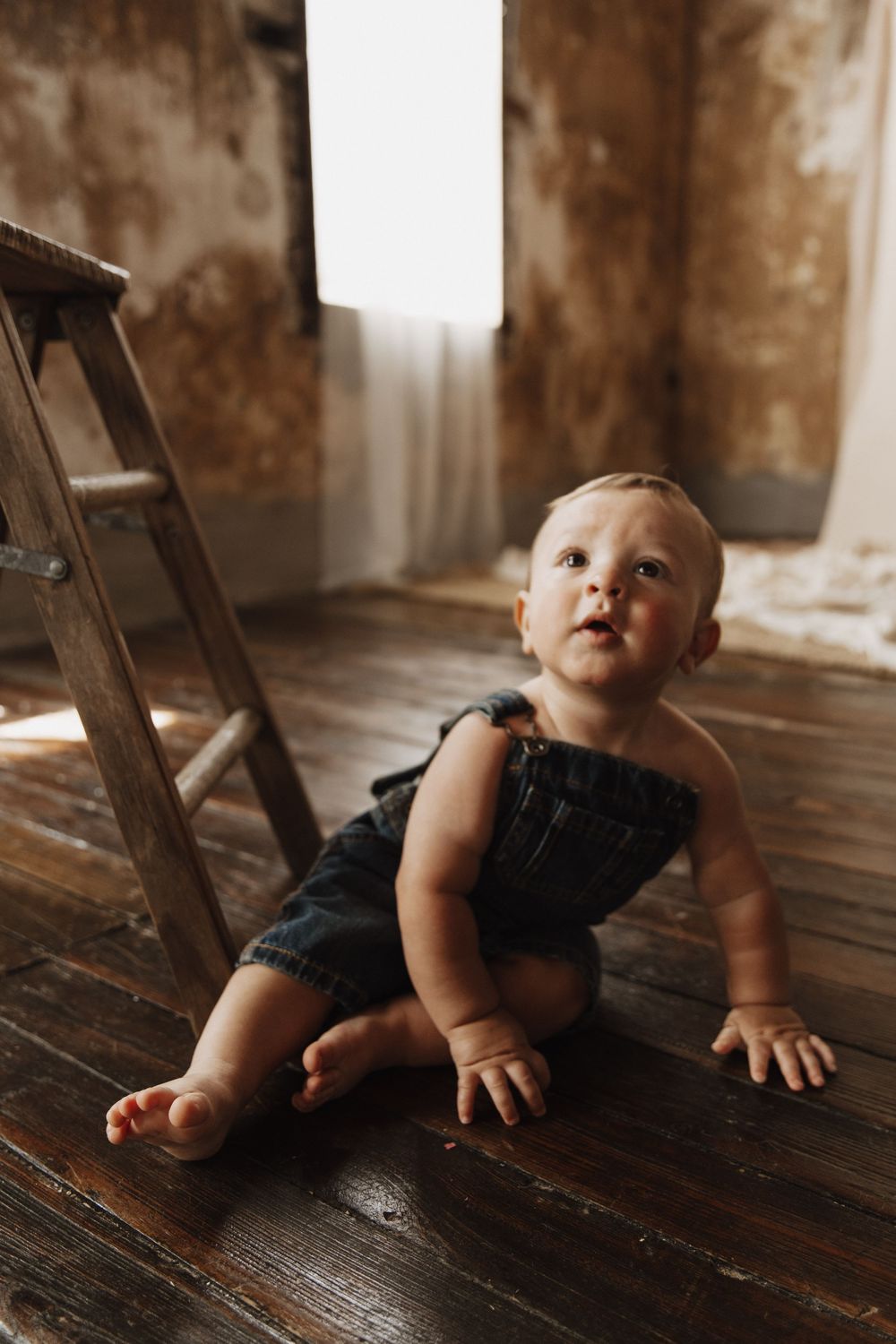 A series of photos showing a baby in denim overalls crawling on a rustic wooden floor.