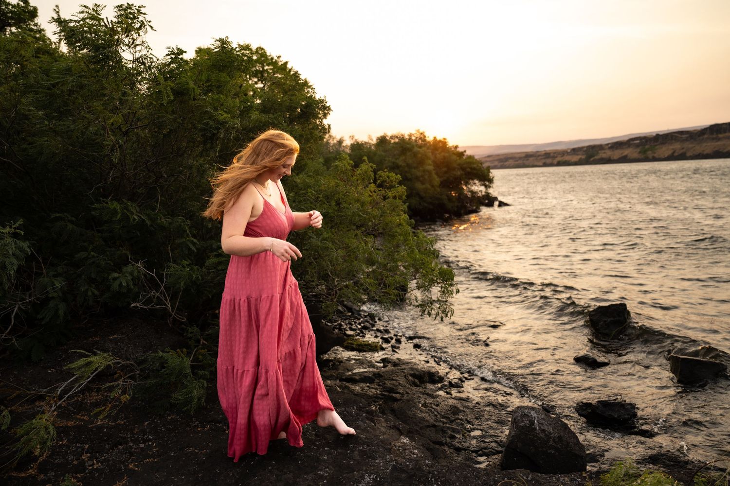 senior session of a girl in a field wearing a black dress with sunflowers on it