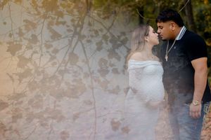 A romantic couple shares an intimate moment against a textured wall in artistic wedding photography.
