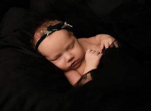 A series of intimate black and white portraits showing different angles of a sleeping newborn baby.