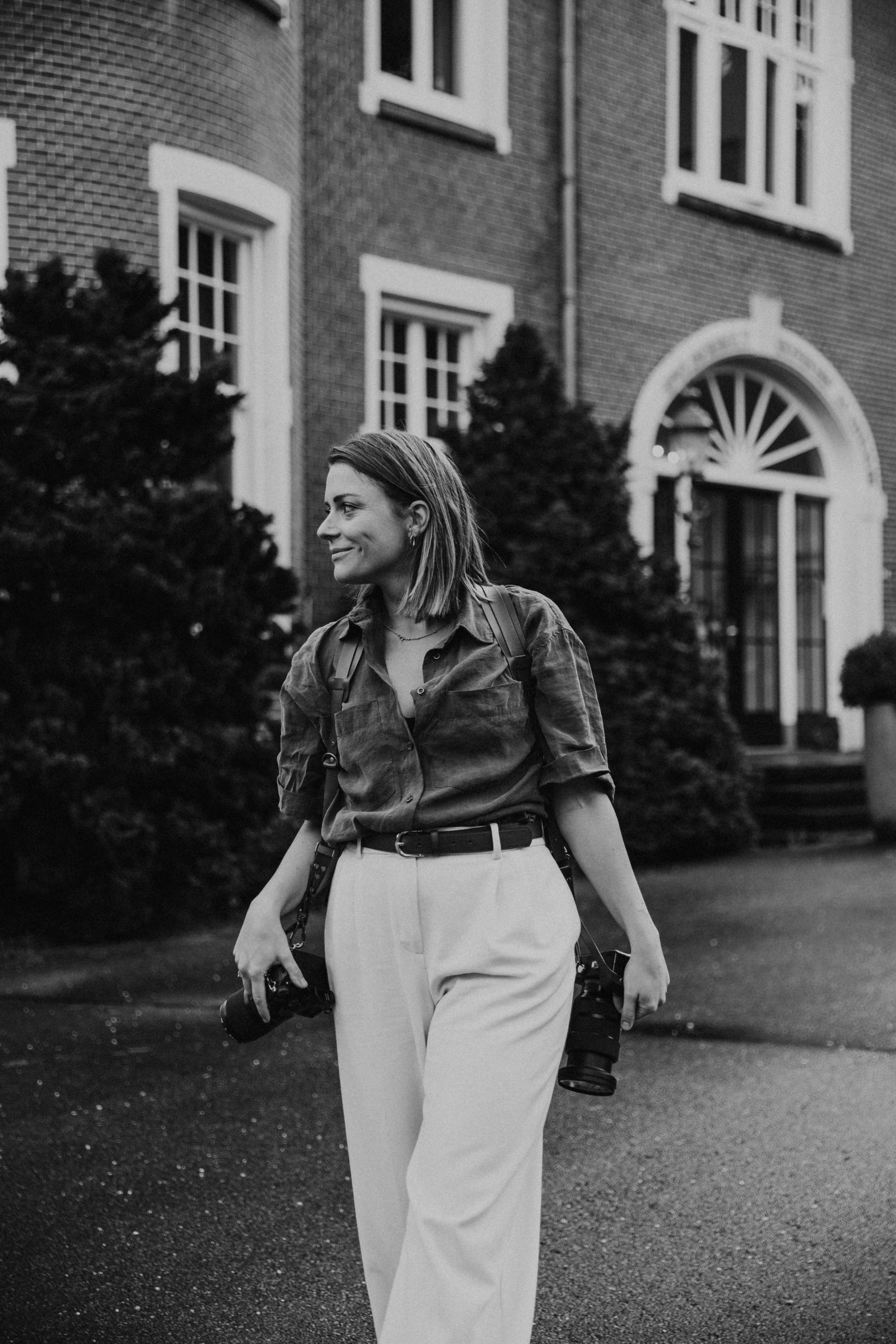 Casual street style photo outside brick building with arched doorway.