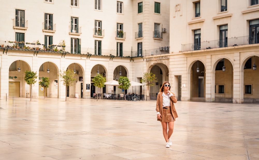 Woman in a beautiful plaza in Spain called Plaza del Ayuntamiento with arched doorways