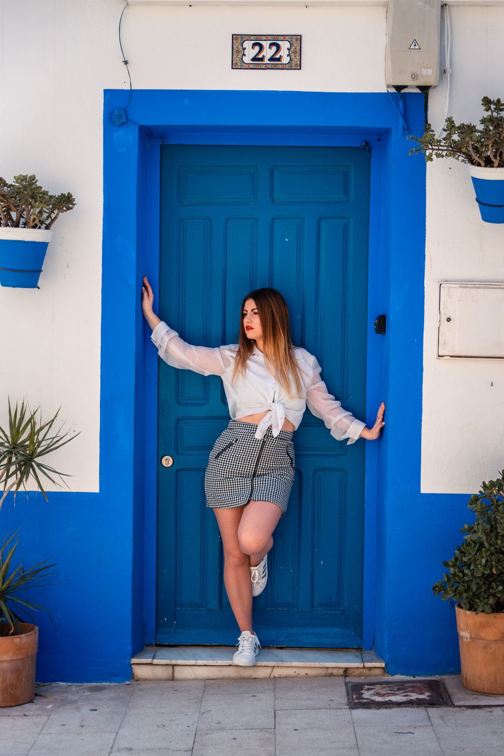 Women in Old town Alicante in a vibrant blue doorway posing for a photo shoot