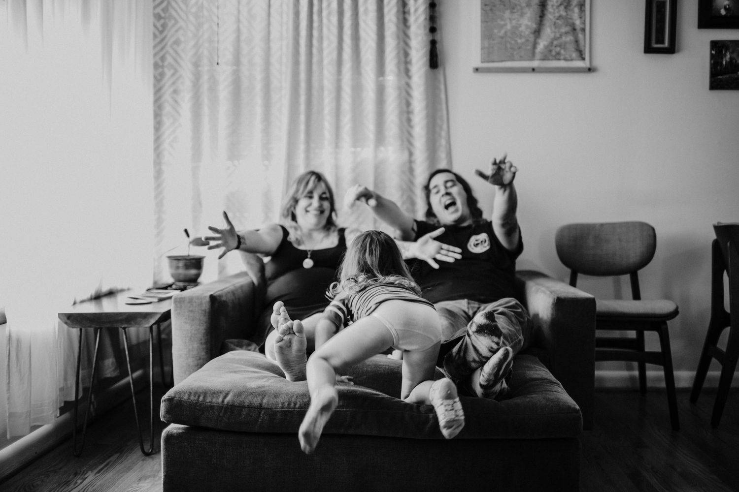 black and white image of parents reaching out for kid running toward them portland oregon rushes & Waves