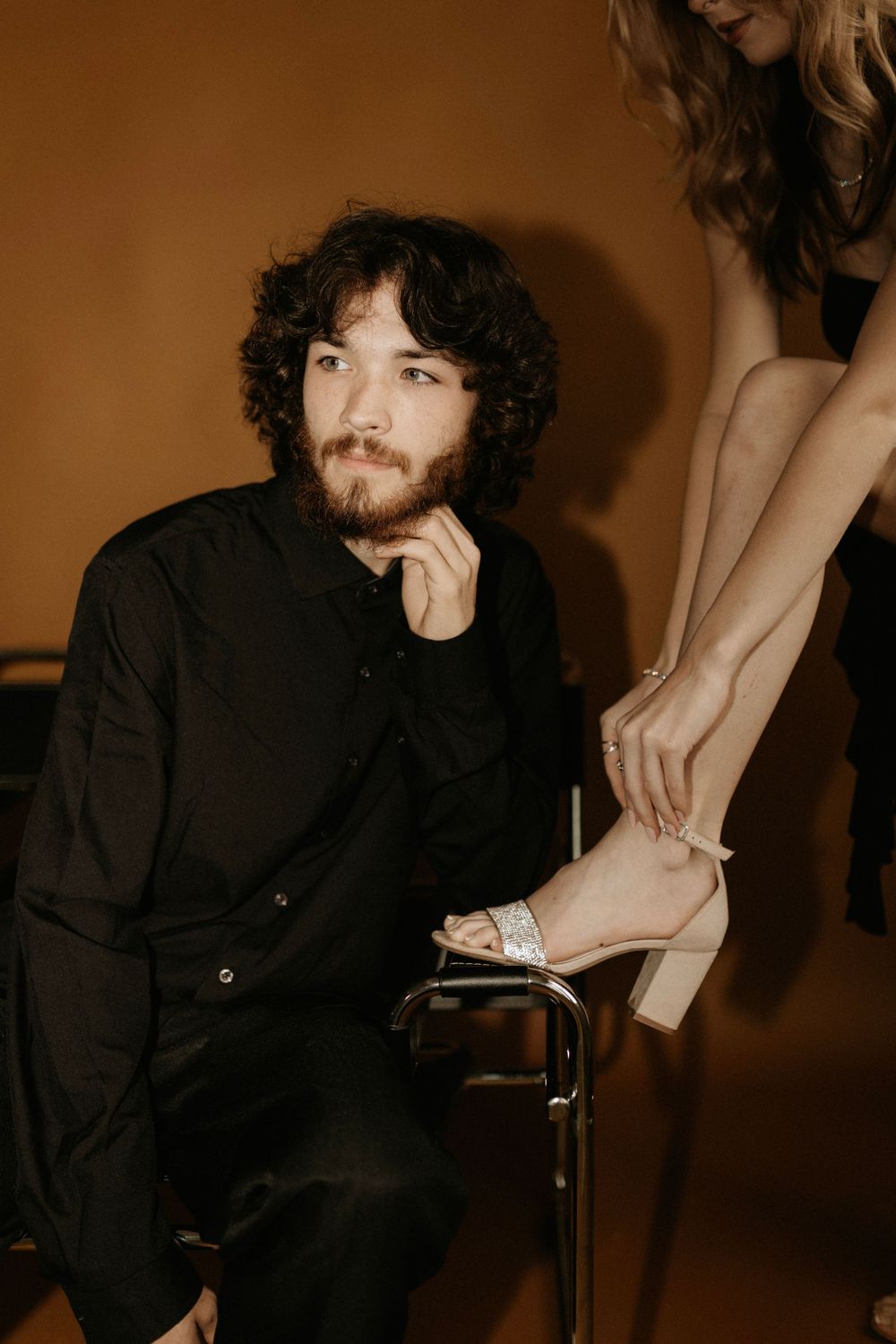 Close-up portrait showing white heels and formal attire against sepia backdrop.